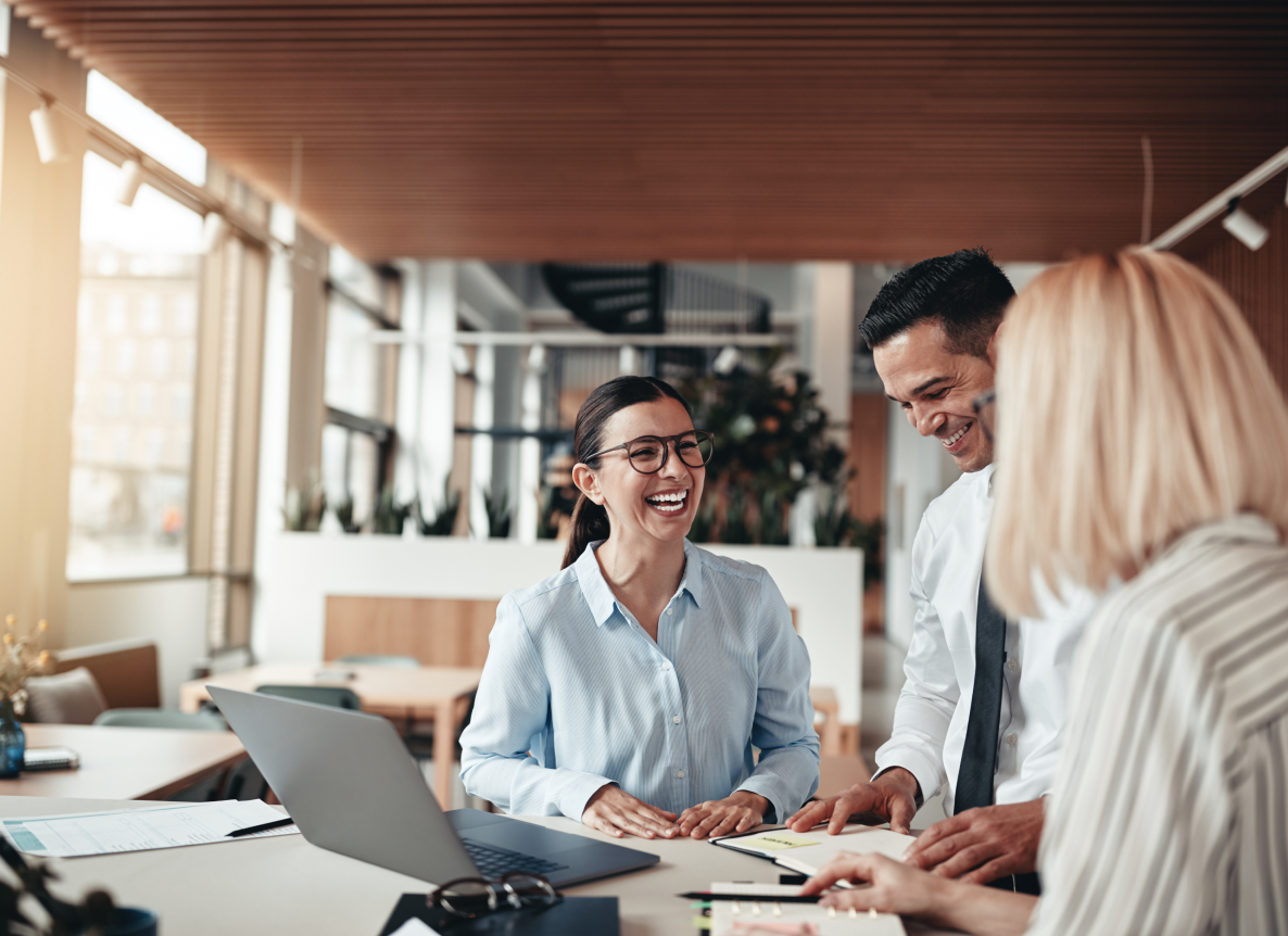 A photograph showing 3 happy colleagues in the workplace